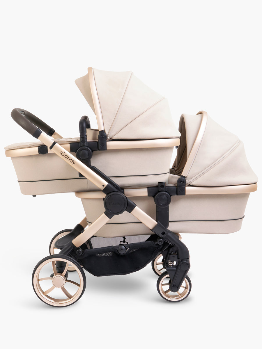 Beige and rose gold baby stroller with two attached carrycots on a white background